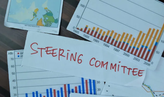 Concept of Steering Committee write on sticky notes isolated on Wooden Table.