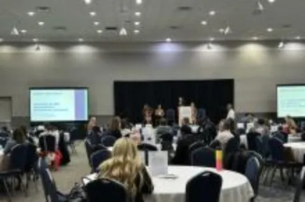 People in a conference room with a screen on the left and right