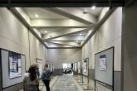 People viewing quality improvement posters in a long room