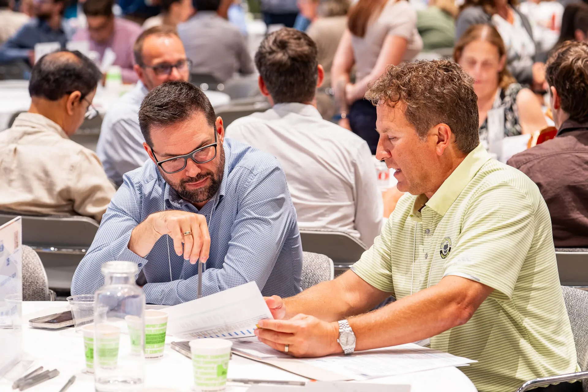 Attendees seated around a conference table during the July HMS meeting, engaged in discussion and collaboration in a professional setting.