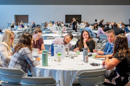 Conference attendees speaking around their table