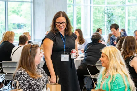 Attendees seated around a conference table during the July HMS meeting, engaged in discussion and collaboration in a professional setting.