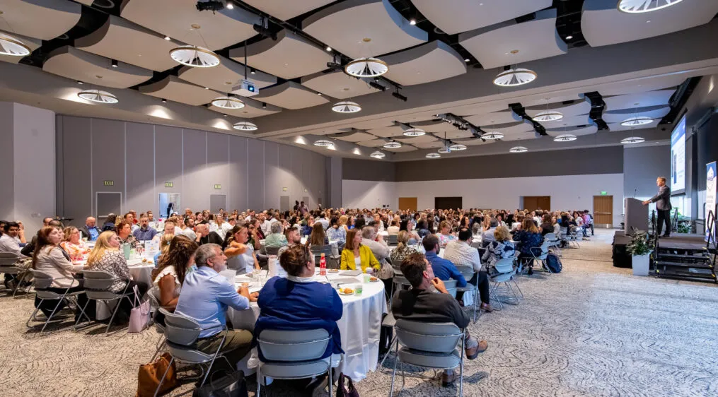 Conference attendees at tables in a conference room
