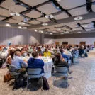 Conference attendees at tables in a conference room
