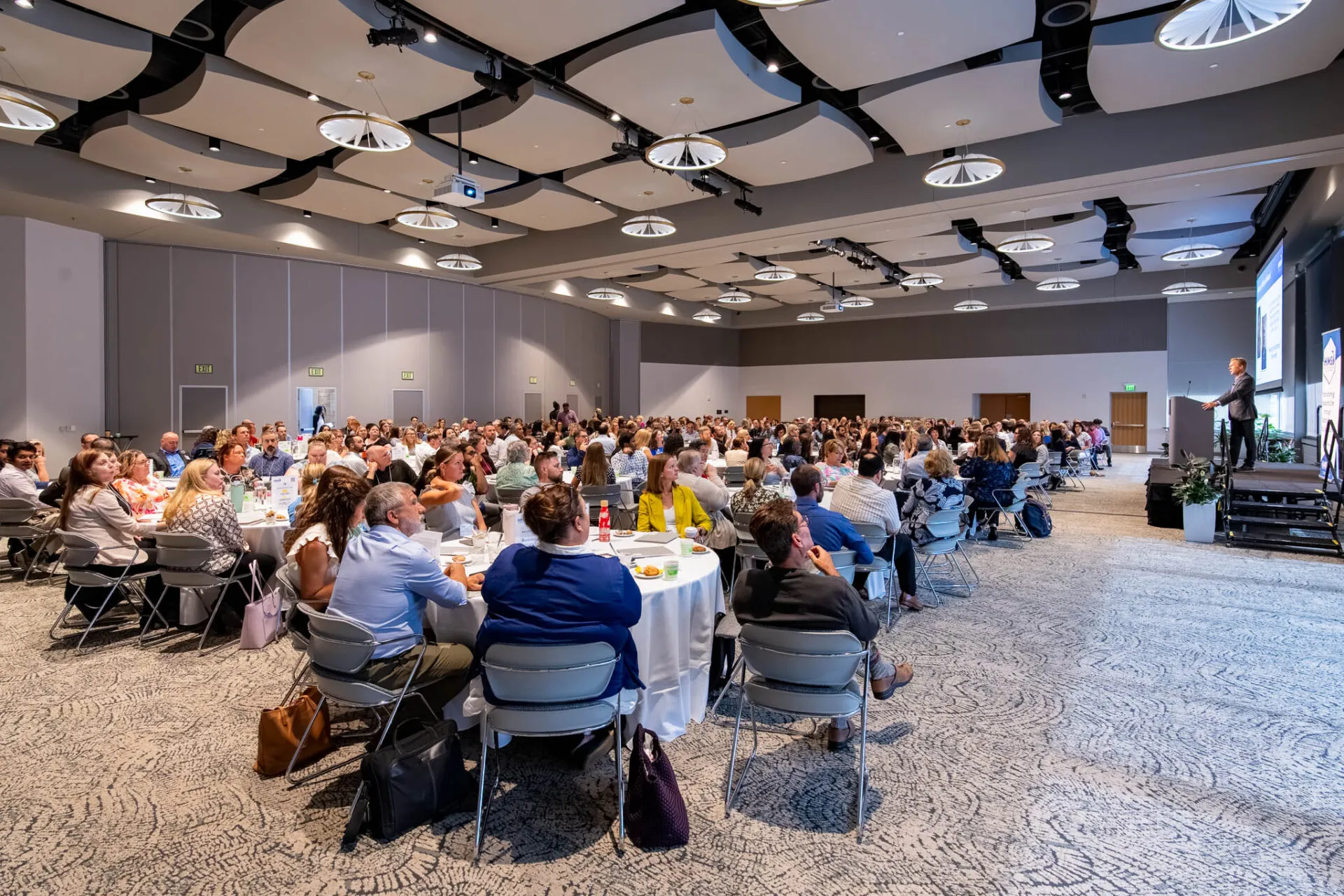 Conference attendees at tables in a conference room
