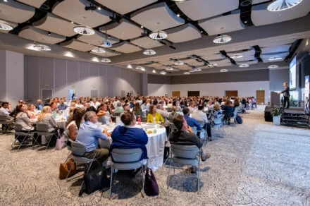 Conference attendees at tables in a conference room