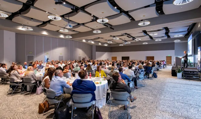 Conference attendees at tables in a conference room