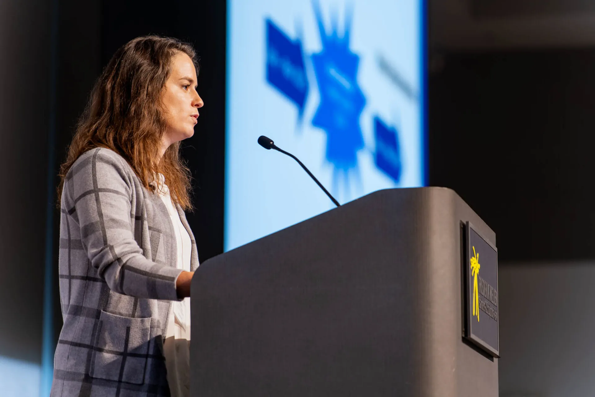 A woman speaking into a microphone on a podium