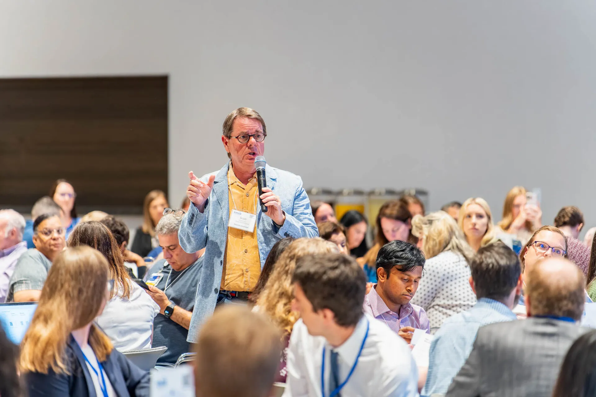 Dr. Scott Kaatz speaking in a microphone to an audience
