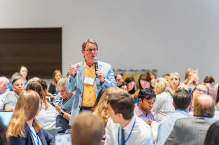 Dr. Scott Kaatz speaking in a microphone to an audience