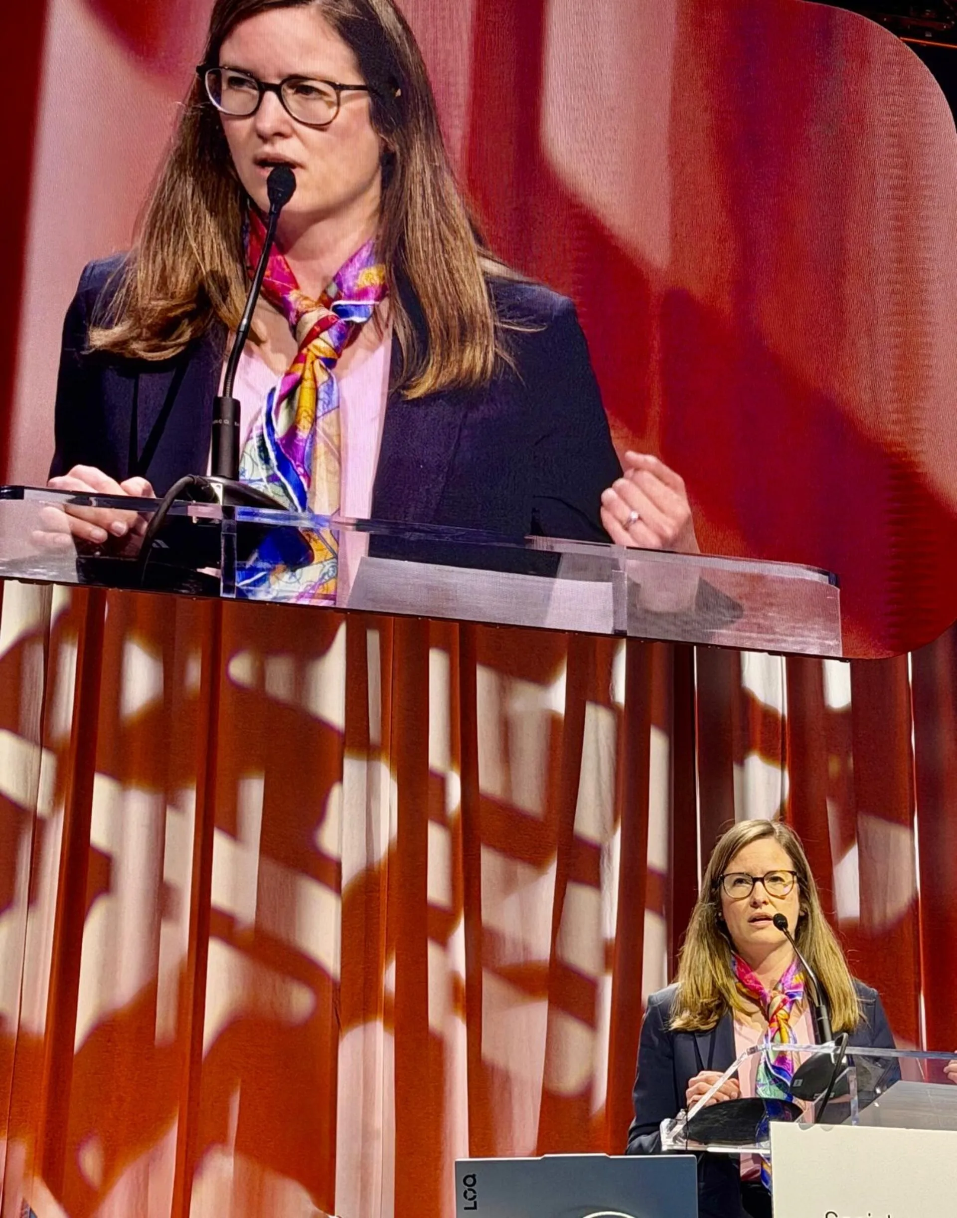 A woman standing at a podium delivering a speech.