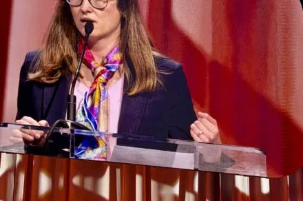 A woman standing at a podium delivering a speech.