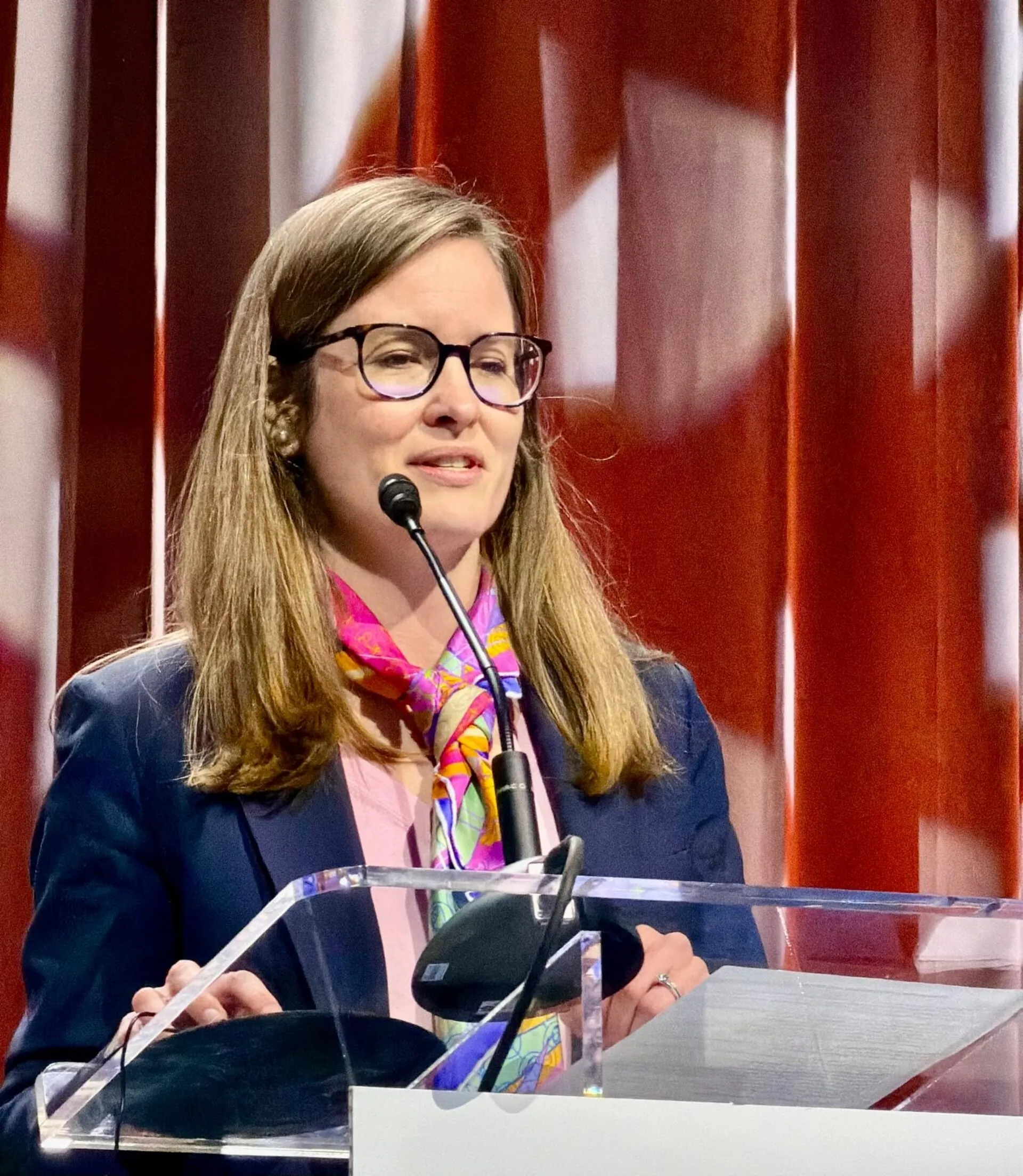 A woman standing at a podium delivering a speech.