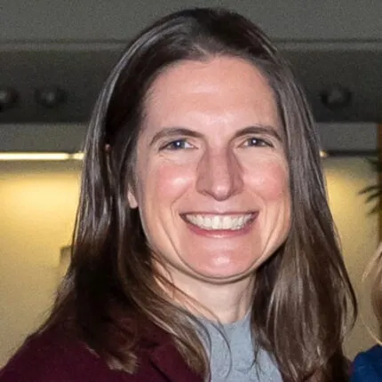 Picture of a woman with long hair, smiling.