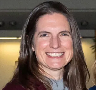 Picture of a woman with long hair, smiling.